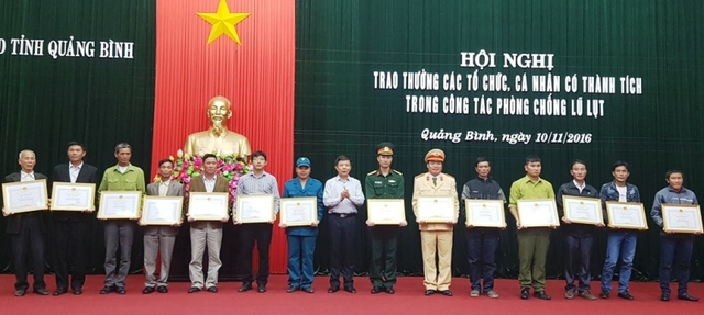 Chủ tịch tỉnh Quảng Bình Nguyễn Hữu Hoài (giữa) trao bằng khen cho các cá nhân xuất sắc trong phòng chống lũ lụt vừa qua. Ảnh: Hương Giang