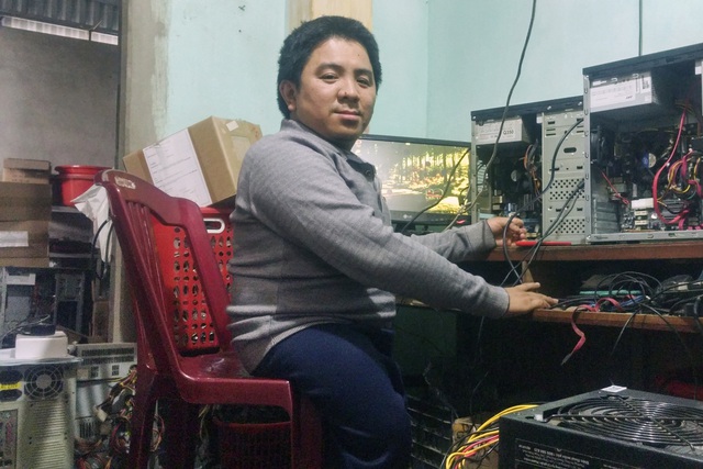 Anh Bùi Minh Pha đang sửa chữa máy tính cho khách. Ảnh: T.G