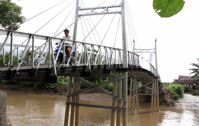 
Những em học sinh của trường tiểu học Hiệp Vinh vui mừng đi trên cây cầu mới.
