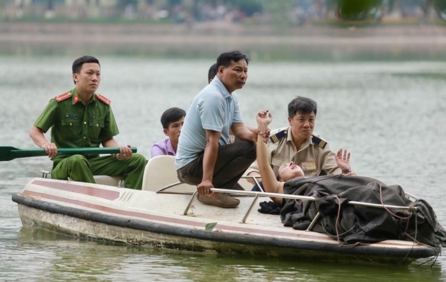 
Lực lượng chức năng dùng thuyền vớt nữ du khách đưa vào bờ. Ảnh: Tuấn Đào.
