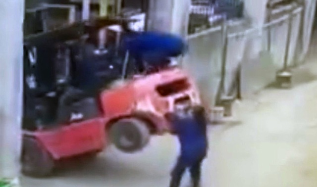 Cố gắng ghì chiếc xe xuống nhưng không thành, nữ công nhân đã bị chiếc xe đè chặt xuống đất.