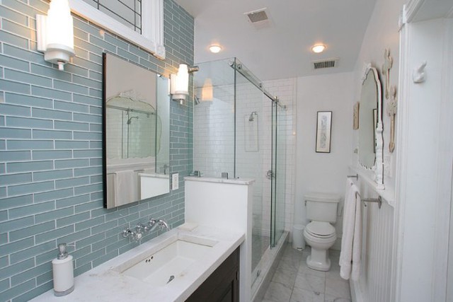 Phòng tắm có sự kết hợp của màu trắng, những khung gương cỡ lớn cùng tường gạch thủy tinh giúp không gian luôn sáng.