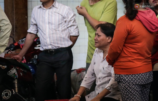 
Bà Dung (bà ngoại 3 đứa trẻ) ngồi khóc nhìn hướng nơi để thi thể gia đình con gái.
