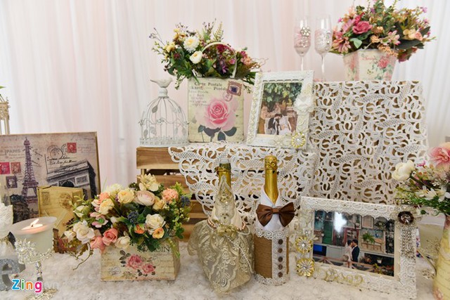 
 Không gian tiệc cưới được trang trí lãng mạn với những giỏ hoa, khung ảnh và nến.
