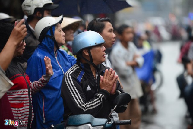 
Mặc cơn mưa to sáng sớm, người dân đội áo mưa, che dù hay thậm chí là để đầu trần để vĩnh biệt sầu nữ. Nhiều người chắp tay cầu nguyện mong bà ra đi thanh thản.

