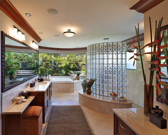 Tường gạch thủy tinh dạng cong trong phòng tắm mang phong cách nhiệt đới giúp không gian vẫn giữ được sự ấm cúng của không gian cũng như vẻ đẹp hiện đại của một phòng tắm hiện đại.