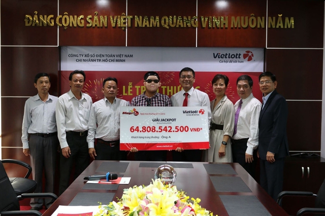 Người tr&uacute;ng giải xổ số gần 65 tỷ đeo mặt nạ đến nhận thưởng