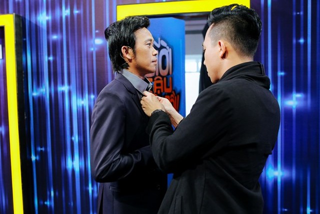 
Trấn Thành tiếp tục giữ vai trò trưởng phòng ở mùa 3. Bạn trai Hari Won chỉnh sửa trang phục giúp Hoài Linh trong cánh gà.
