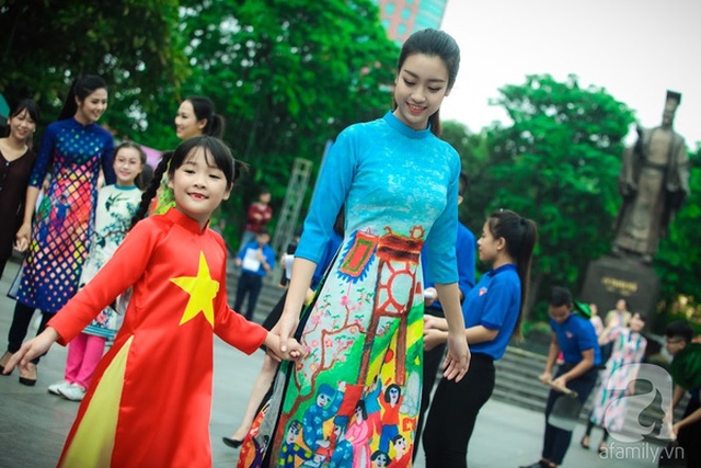 
Trong khi Hoa hậu Việt Nam 2016 thân thiện nắm tay một bé gái diện áo dài có màu quốc kỳ Việt Nam...
