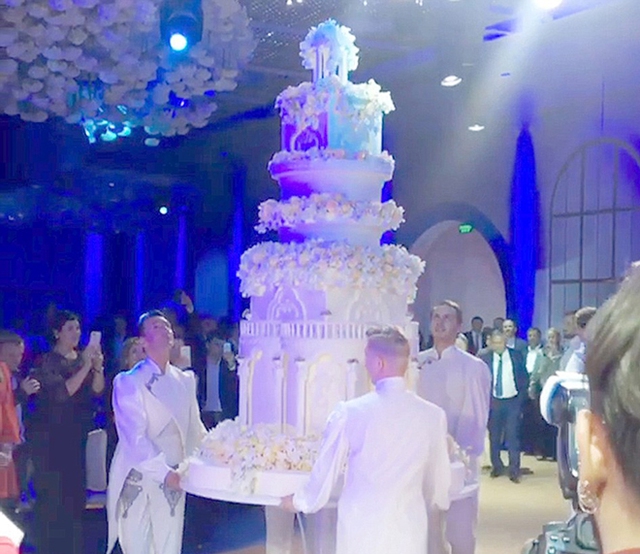 
Gia đình tài phiệt gây kinh ngạc cho khách mời với chiếc bánh cưới cao 3 mét, do ông Renat Agzamov, một nghệ nhân làm bánh nổi tiếng, chế tác và cần 3 chàng trai mới bê được vào hôn trường.
