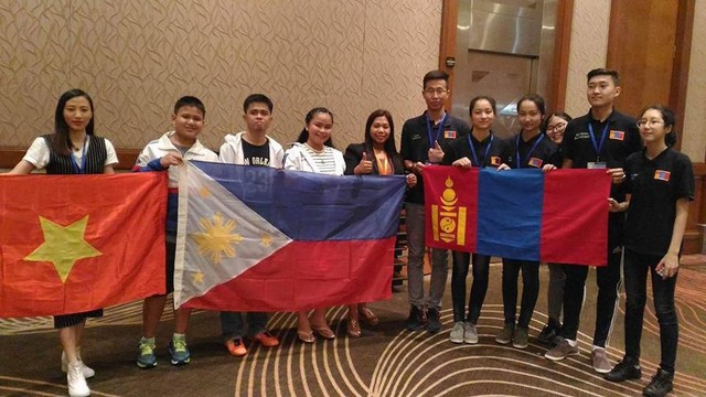 
Vân cầm cờ Việt Nam chụp chung cùng các đội tuyển nước bạn. Ảnh: NVCC

