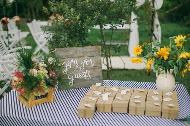 B&agrave;n để qu&agrave; tặng d&agrave;nh cho kh&aacute;ch mời được trang tr&iacute; đơn giản nhưng xinh xắn. Từng m&oacute;n q&ugrave;a được c&ocirc; d&acirc;u ch&uacute; rể chọn mua, thiệp được ch&iacute;nh c&ocirc; d&acirc;u v&agrave; ch&uacute; rể viết tay, từng hộp qu&agrave; được b&ecirc;n wedding planner Je taime g&oacute;i cẩn thận bằng d&acirc;y thừng k&egrave;m tag quả thơm đ&aacute;ng y&ecirc;u.