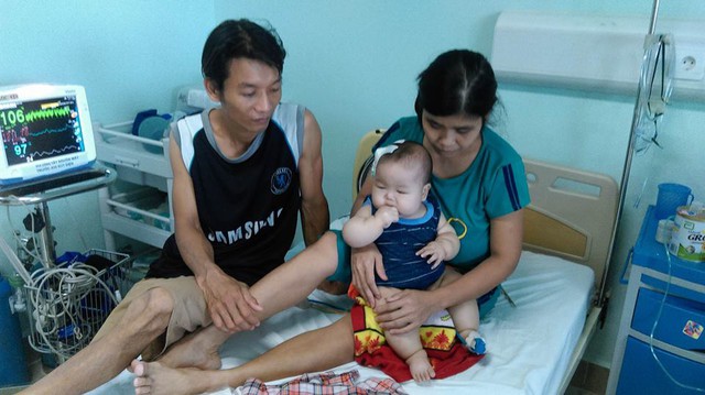 
Anh Hoàng Văn Hiếu và chị Trương Thị Hoa đang chăm sóc con tại viện. Ảnh: Ngọc Thi
