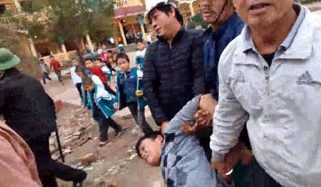 
Anh Cao bị nhóm công an xã lôi đi trước sự chứng kiến của rất đông học sinh trường tiểu học Vĩnh Phong ngày 15/12/2017.
