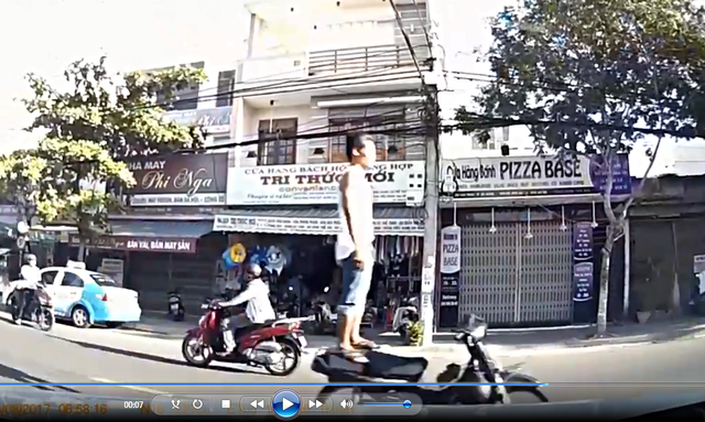 Nam thanh niên đi xe bằng chân trên đường phố Đà Nẵng. Ảnh cắt từ clip