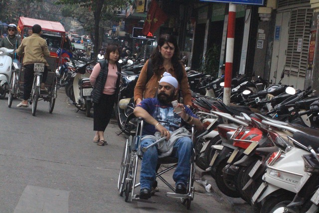 Xe máy đẩy người đi bộ xuống lòng đường ở phố Cầu Gỗ.