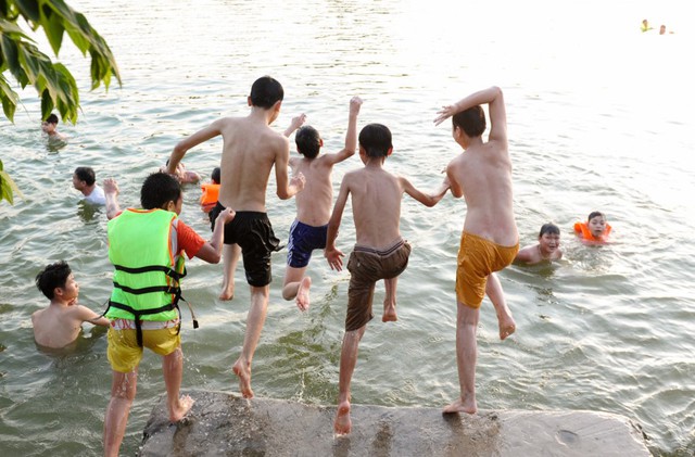 Trẻ em giải nhiệt bằng cách tắm sông. Ảnh: H.P