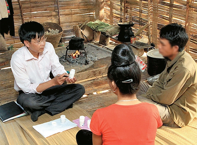 Cán bộ y tế huyện Mai Sơn, tỉnh Sơn La tư vấn, hướng dẫn đối tượng nhiễm HIV ở xã Chiềng Lương uống thuốc ARV. ảnh: P.V