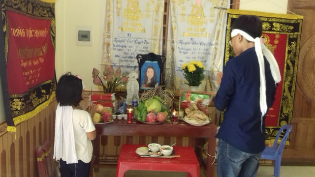Hai đứa con còn thơ dại của vợ chồng chị Nguyễn Thị Vân, anh Nguyễn Hữu Lâm, chịu tang bên bàn thờ mẹ. Ảnh: Ngọc hưng