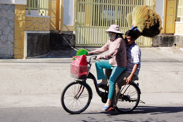 Với một mắt còn nhìn thấy ánh sáng lờ mờ, hàng ngày chị Trắc chở chồng đi khắp các con đường ngõ hẻm để bán chổi.