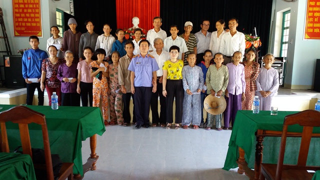 Nhà báo Thu Hương (đeo kính đứng giữa) và ông Phạm Văn Bảy, Viện trưởng VKND huyện Thăng Bình (Quảng Nam) tặng quà tri ân Tết Đinh Dậu 2017 cho các gia đình CM khó khăn của huyện Thăng Bình