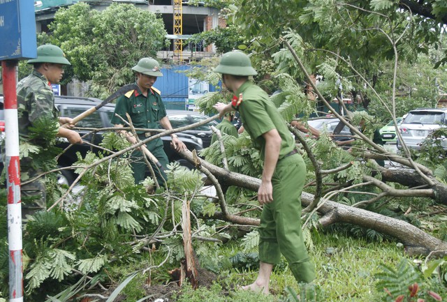 Lực lượng quân đội, công an giúp dân giải tỏa những con đường sau bão.