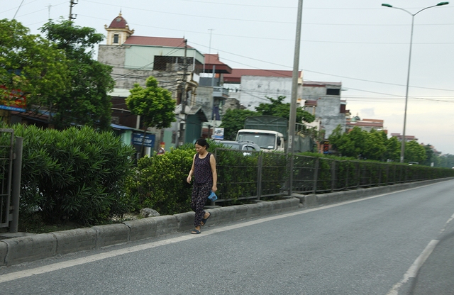 Một phụ nữ vô tư đi bộ ngay trong làn xe ô tô để đến đoạn sang đường.