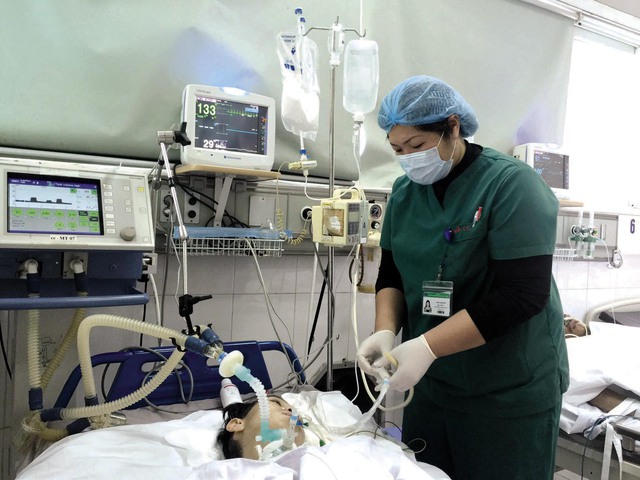Điều dưỡng viên Phạm Thị Hạnh chăm sóc bệnh nhân tại Khoa Cấp cứu, Bệnh viện Bệnh Nhiệt đới Trung ương. Ảnh: Võ Thu
