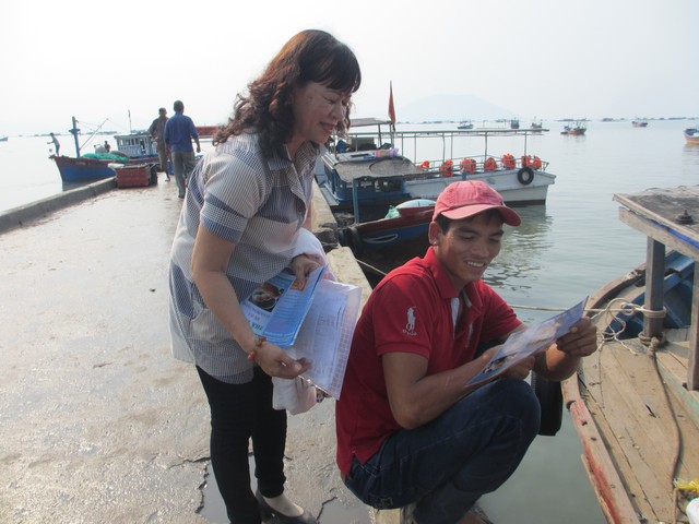 Phát tờ rơi tuyên truyền cho người dân vùng đảo Vạn Thạnh. Ảnh: T.Nguyễn