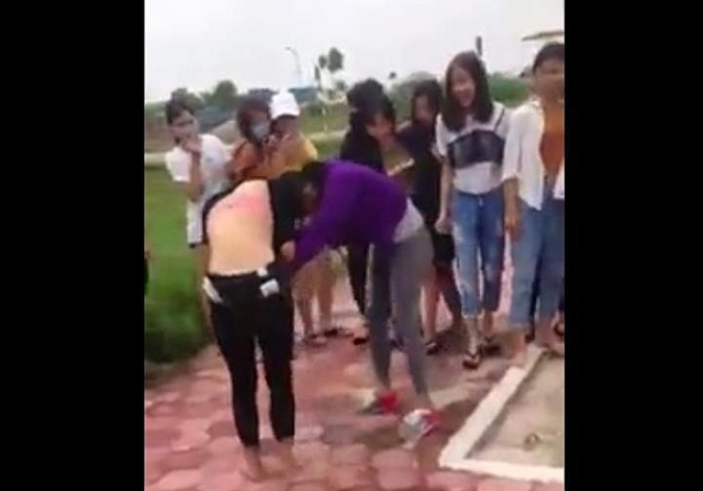 Trong lúc 2 nữ sinh đánh nhau có nhiều học sinh đứng xem và quay clip. (Ảnh: Cắt từ clip)
