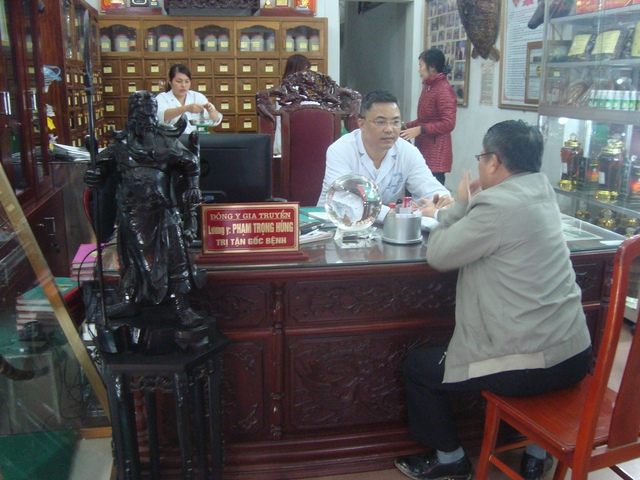 Lương y Phạm Trọng Hùng đang thăm khám cho bệnh nhân tại nhà thuốc của mình
