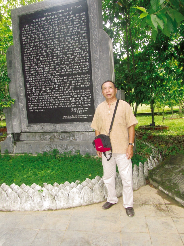 Tác giả bên bia đá khắc lá thư của chị Võ Thị Tần.