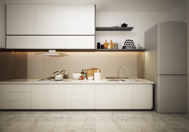 Phòng bếp khá rộng với tông màu trắng chủ đạo. Cạnh bếp đặt một chiếc tủ lạnh lớn.