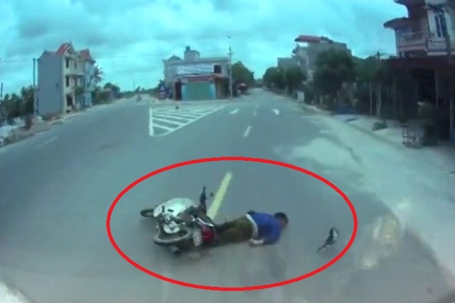 Sau khi vượt phải bất thành, người đàn ông đã va chạm vào ô tô rồi văng xuống đường nằm bất tỉnh. (Ảnh: Cắt từ clip)