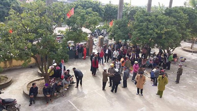 
Hàng trăm người dân xã Vĩnh Phong tập trung tại trụ sở UBND xã chứng kiến việc anh Cao bị còng tay. Ảnh: CTV
