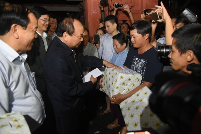 
Thủ tướng Nguyễn Xuân Phúc thị sát tình hình mưa lũ, hỏi thăm, động viên người dân TP Hội An bị thiệt hại sau cơn bão số 12.     Ảnh: C.P

