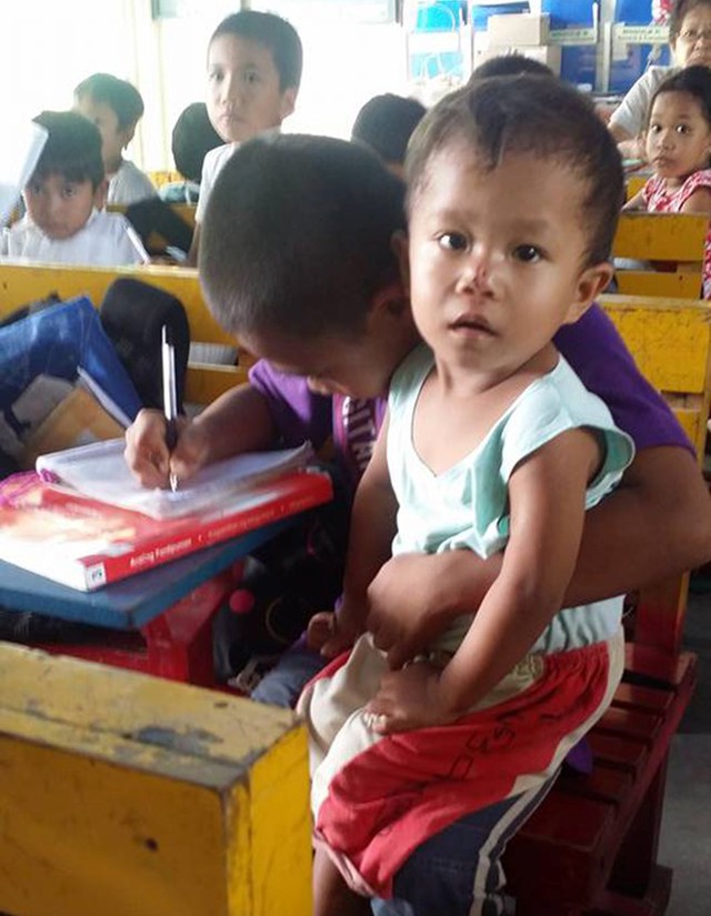 
Bức ảnh Mateo vừa bế em vừa học b&agrave;i lay động tr&aacute;i tim cộng đồng mạng. Ảnh: Shyla Mie Brillantes Blasico.
