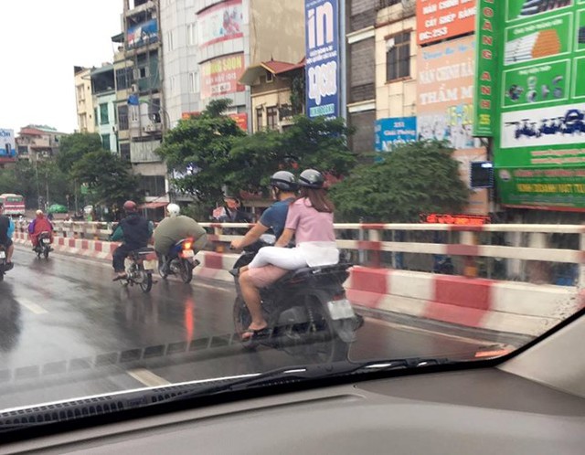 
Hồi đầu tháng 9/2016, bức ảnh chụp một cô gái ngồi sau xe SH thản nhiên vắt chân lên đùi người lái để tránh mưa bẩn quần cũng gây nhiều bất bình cho người đi đường.
