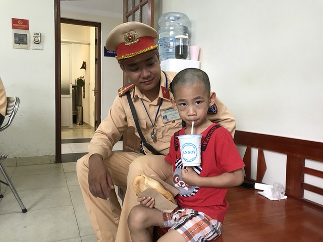 Thượng uý Nguyễn Duy Linh ân cần bên bé Minh tại trụ sở Đội CSGT số 6, Hà Nội