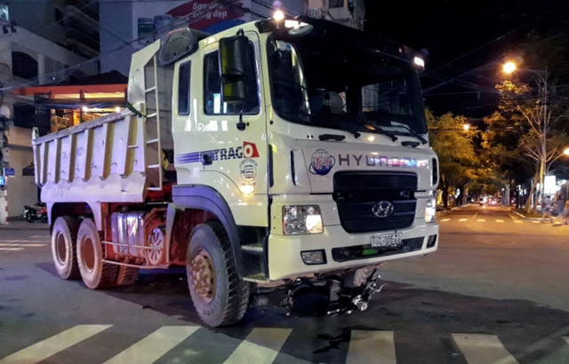 Chiếc xe đạp điện nằm gọn dưới gầm xe ben. Ảnh: An B&igrave;nh
