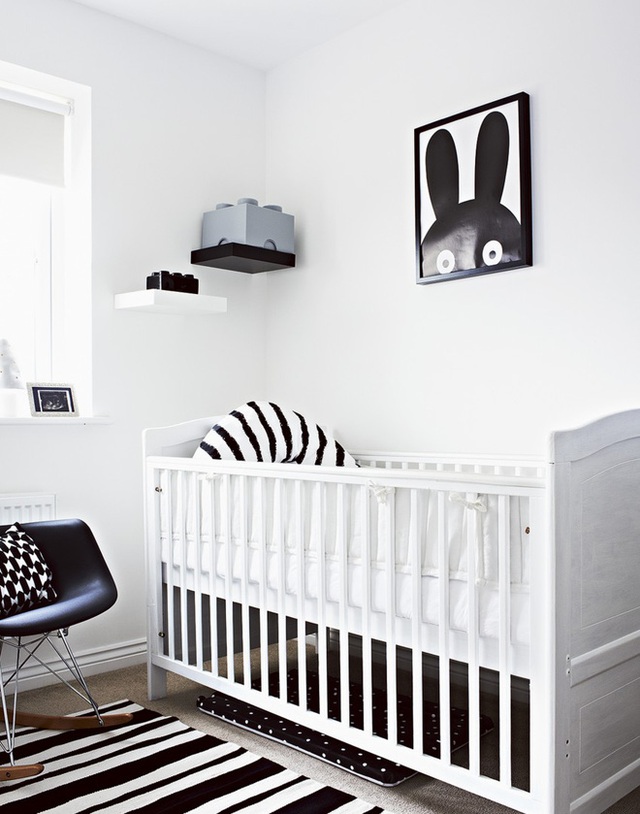 Những vật dụng trên tường và ghế được trang trí màu đen cân bằng với nội thất màu trắng, tạo ra bảng màu hài hòa, cân đối cho không gian nơi giường cũi.