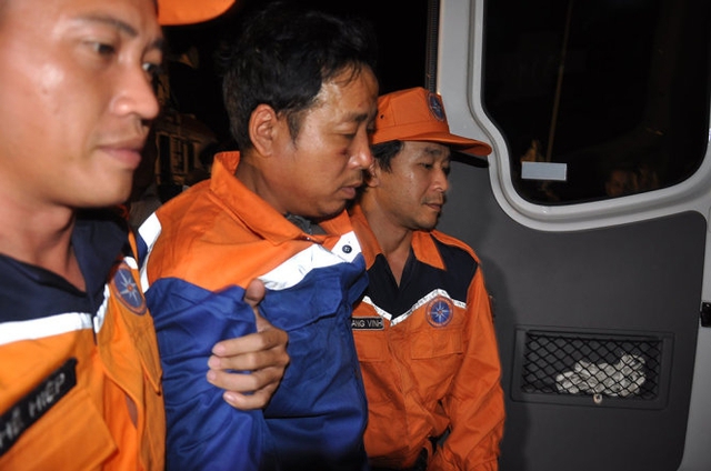 
Thuyền trưởng Nguyễn Viết Thắng (người đi giữa) được dìu ra xe cấp cứu
