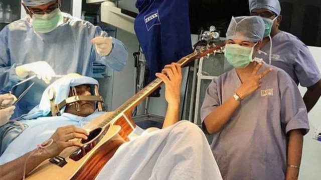 Ông Abhishek Prasad chơi đàn trong khi các bác sĩ đang mổ cho ông - Ảnh: PTI