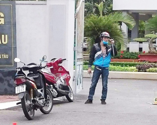 
Nguyễn Song Phương cầm mã tấu đứng trước cổng hội trường Thành ủy Vũng Tàu. Ảnh: G.N.
