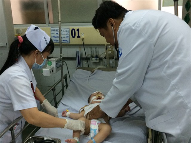 
Bác sĩ Đinh Tấn Phương, Trưởng khoa Cấp cứu Bệnh Nhi đồng 1 đang khám cho bệnh nhi.
