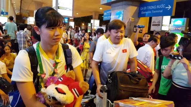 Thầy trò Ánh Viên (trái) được chào đón tại sân bay Tân Sơn Nhất. Ảnh: T.P