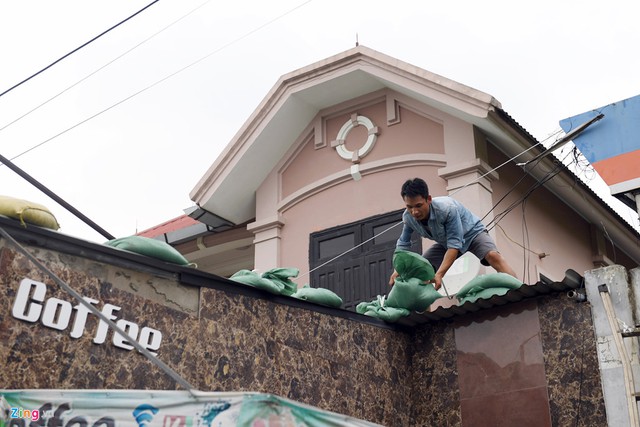 Chiều tối 14/9, trước khi bão số 10 (Doksuri) đổ bộ, người dân miền Trung phải chạy đua với thời gian, tất bật gia cố mái nhà ứng phó với bão.