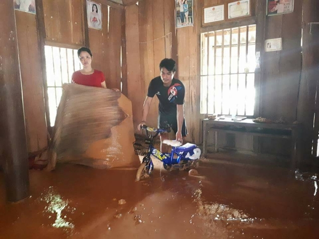 
Anh Đinh Công Huy cùng vợ đang dọn dẹp đống bùn đất trong nhà.
