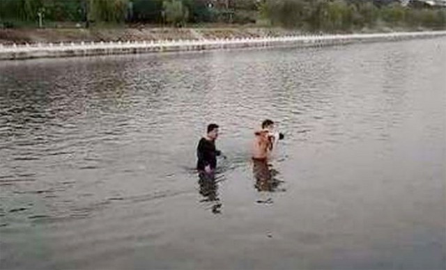 Nam b&aacute;c sĩ c&ugrave;ng một người đ&agrave;n &ocirc;ng nhảy xuống s&ocirc;ng để cứu em b&eacute;.