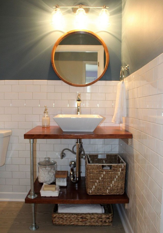 Thiết kế đơn giản đầu tiên mà chúng tôi gợi ý là một kệ gỗ cùng bồn rửa tay bên trên khá tiện lợi. Khoảng không gian bên giữa kệ sẽ cho bạn diện tích để lưu trữ các đồ dùng trong nhà tắm khá thoải mái.